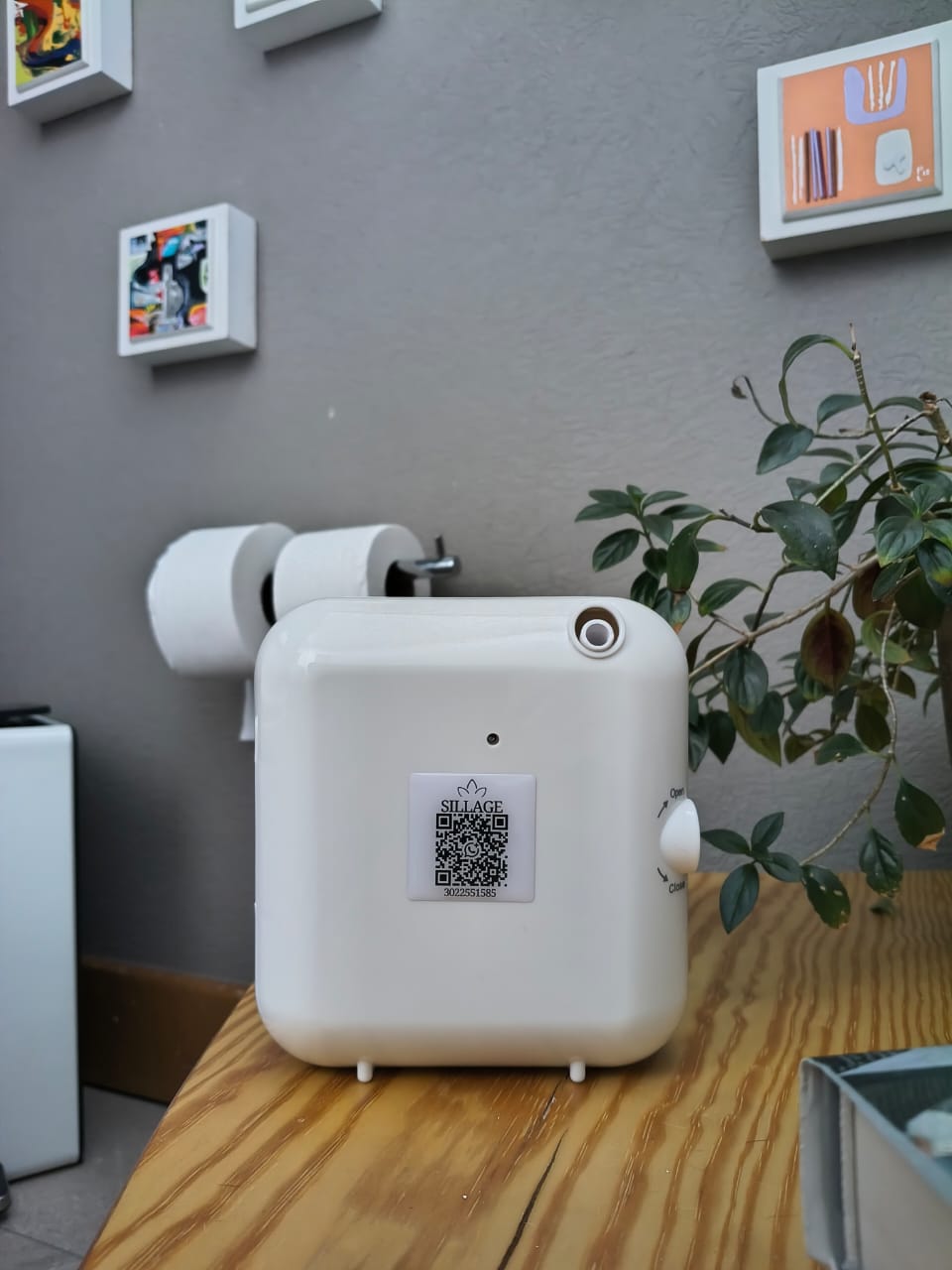 Difusor blanco Sillage instalado en un baño junto a plantas y elementos decorativos.