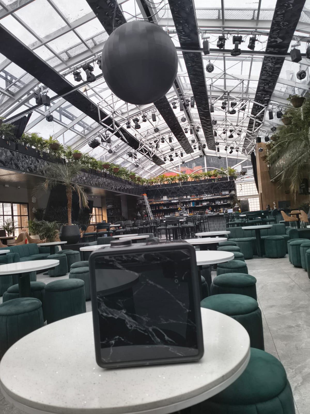 Equipo de aromatización Sillage instalado sobre una mesa en un restaurante de mobiliario verde.
